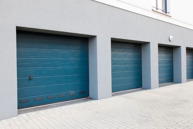 Modern blue garage doors installed on a Laplace home.