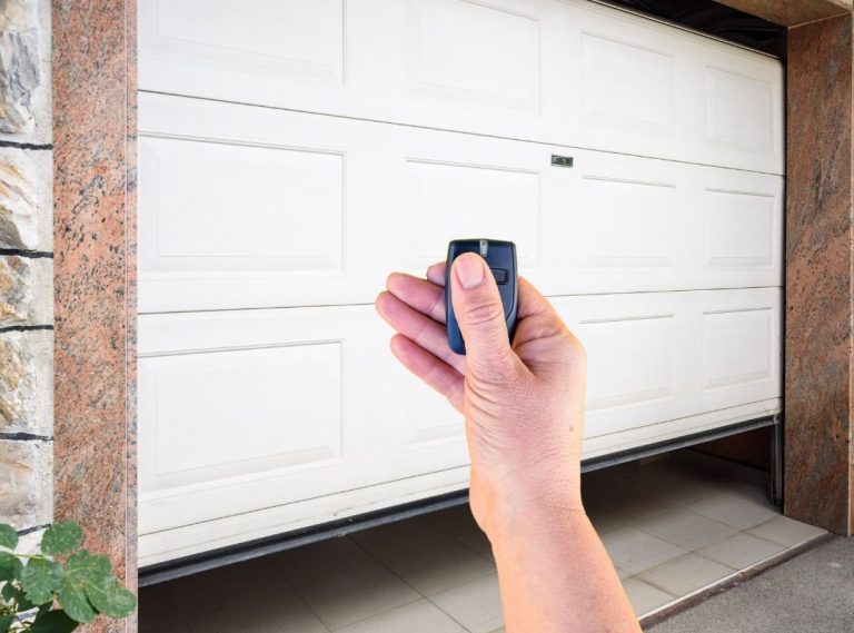 Hand holding garage door remote opener in Kenner.