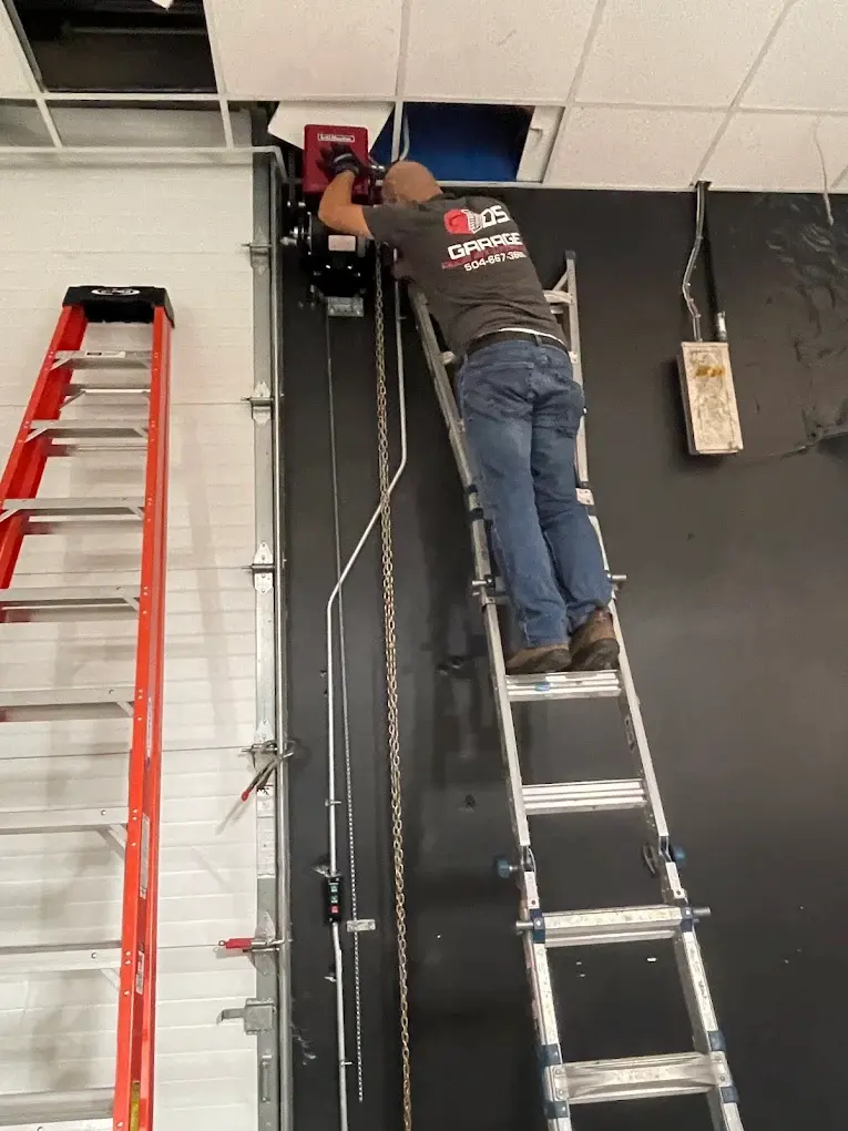 Technician servicing a commercial overhead door operator with access controls in New Orleans