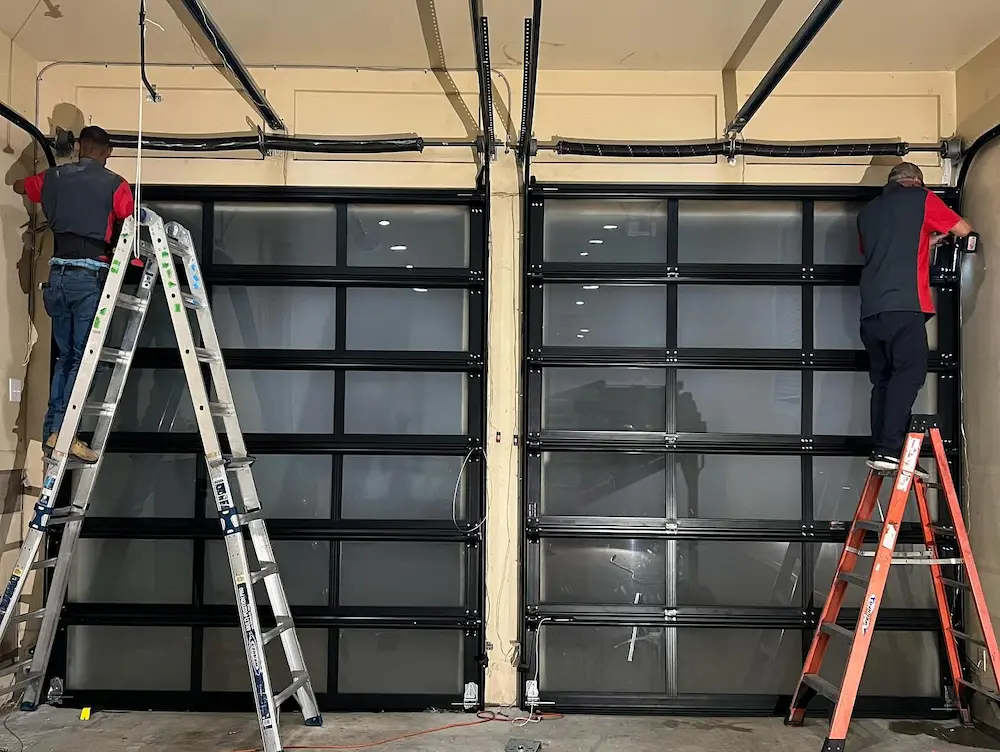 Technician repairing a commercial sectional overhead door