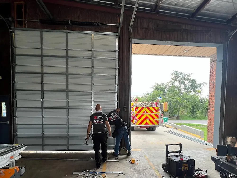 Technician performing preventative maintenance on overhead door hardware