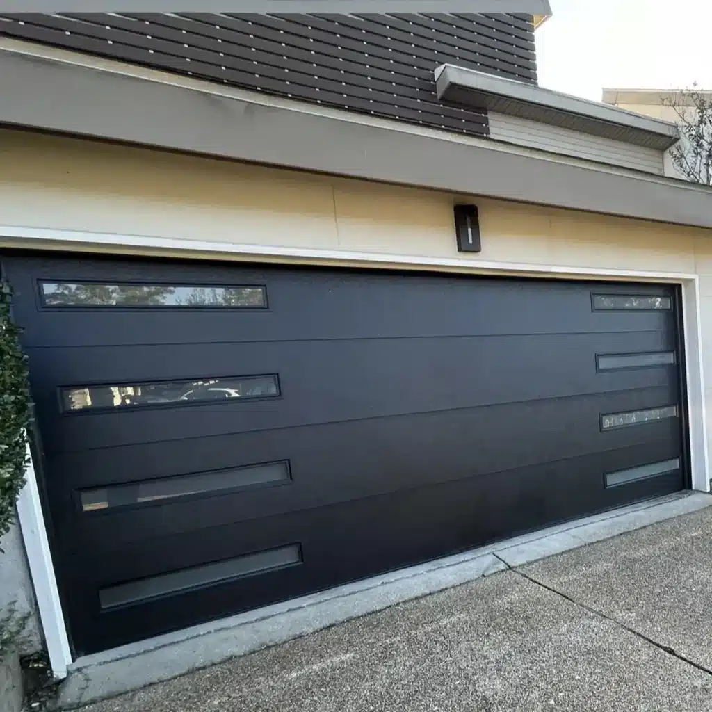 Modern charcoal garage door with horizontal window panels installed in New Orleans