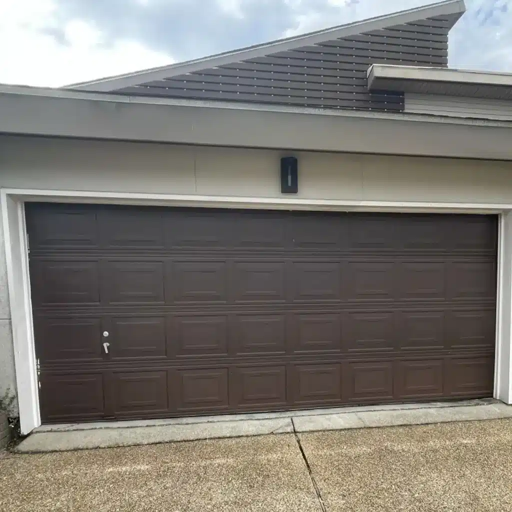 Dark brown two-car garage door before upgrade on a New Orleans area home
