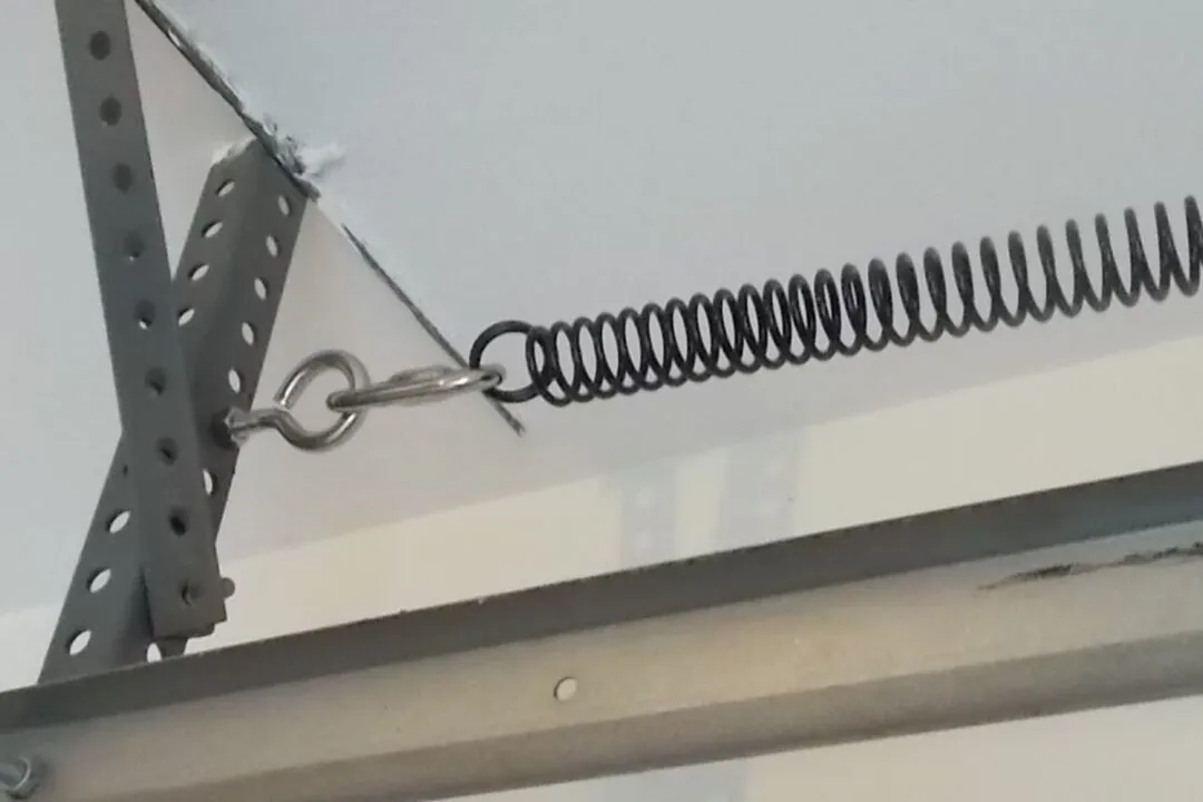 garage door extension spring installed along horizontal track with safety cable