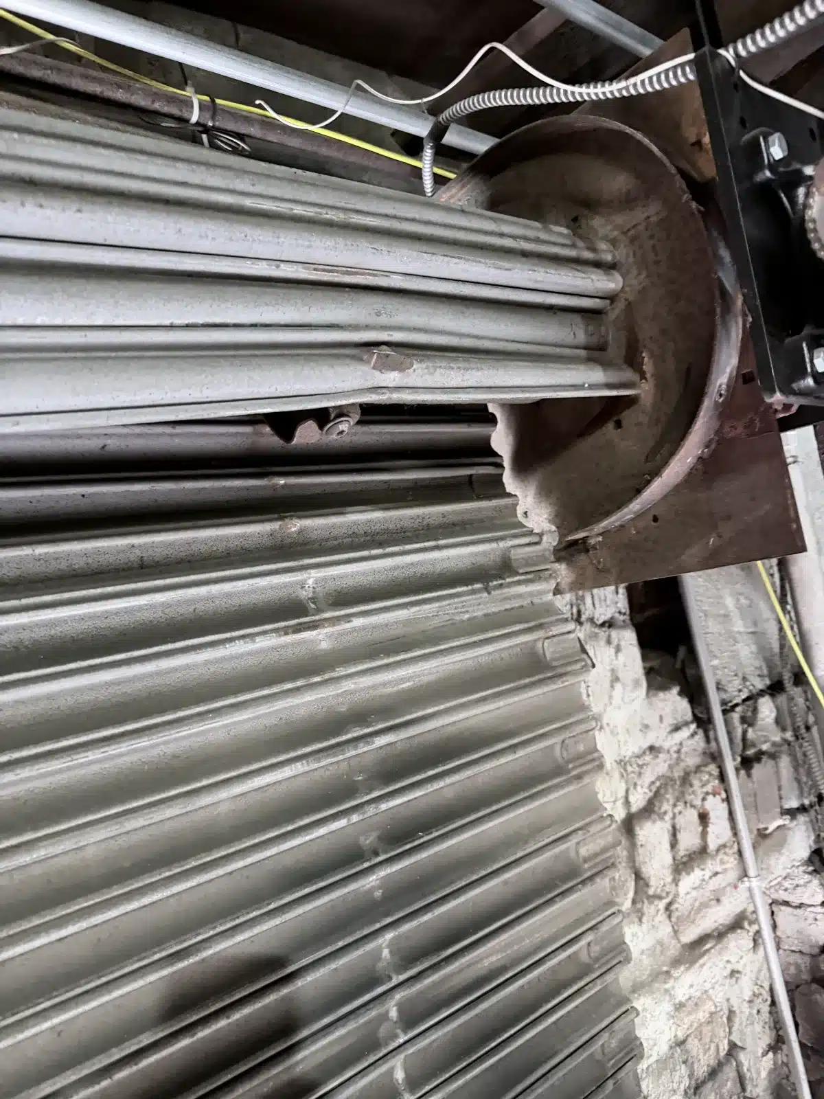 Rolling steel door barrel with spring assembly exposed during spring replacement in New Orleans Louisiana